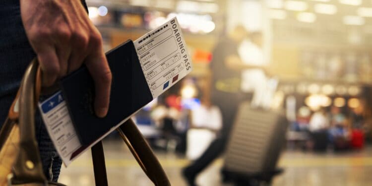 person holding boarding pass at airport